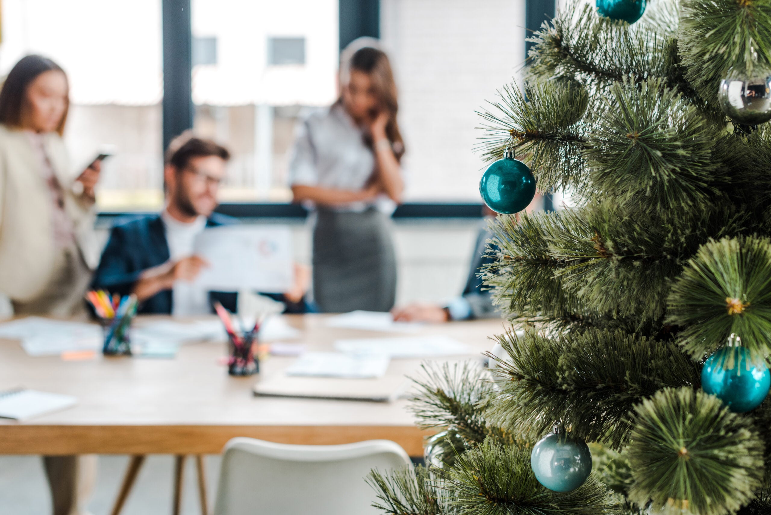 Selective focus of decorated christmas tree near multicultural c