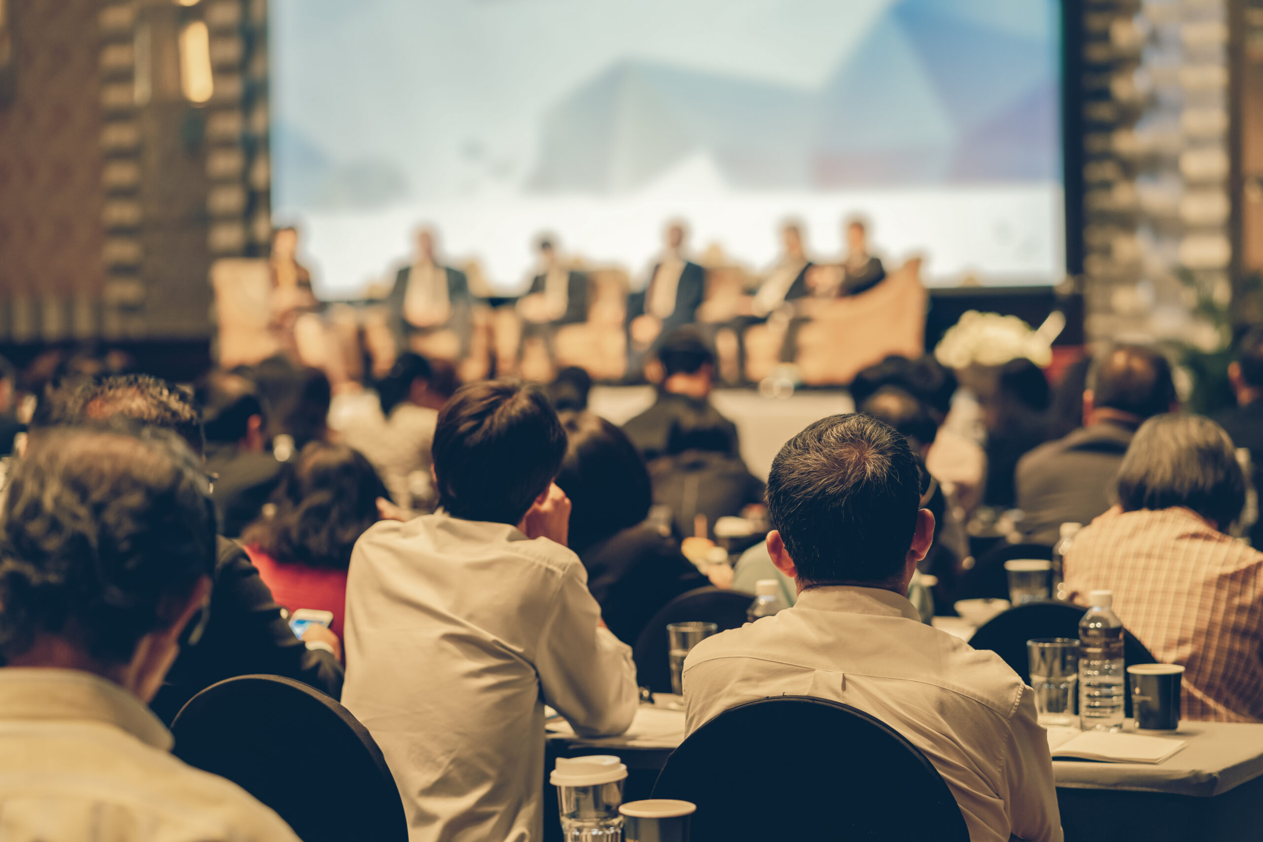 Rear view of Audience listening Speakers on the stage in the conference hall or seminar meeting, business and education about investment concept