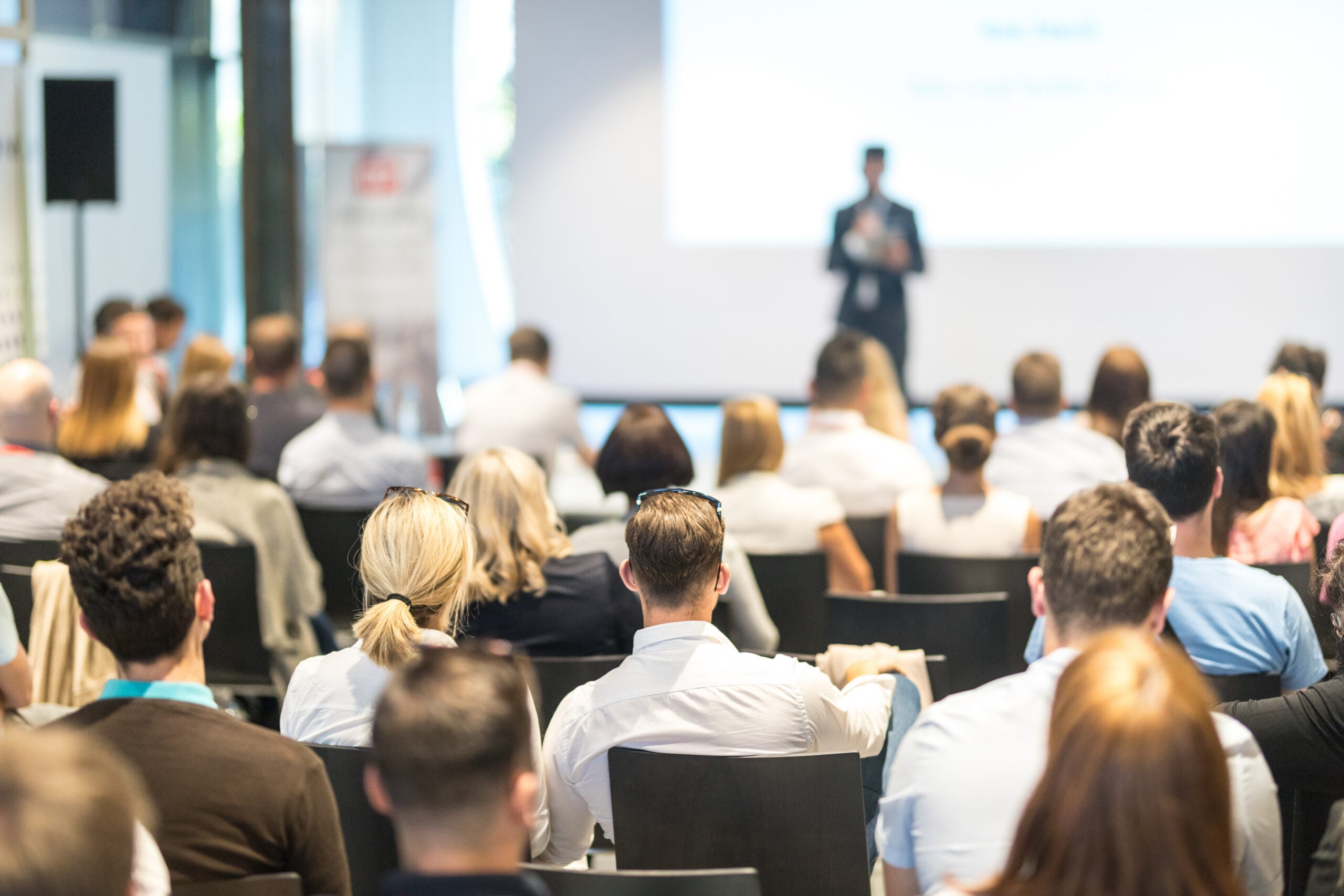 Business speaker giving a talk at business conference event.