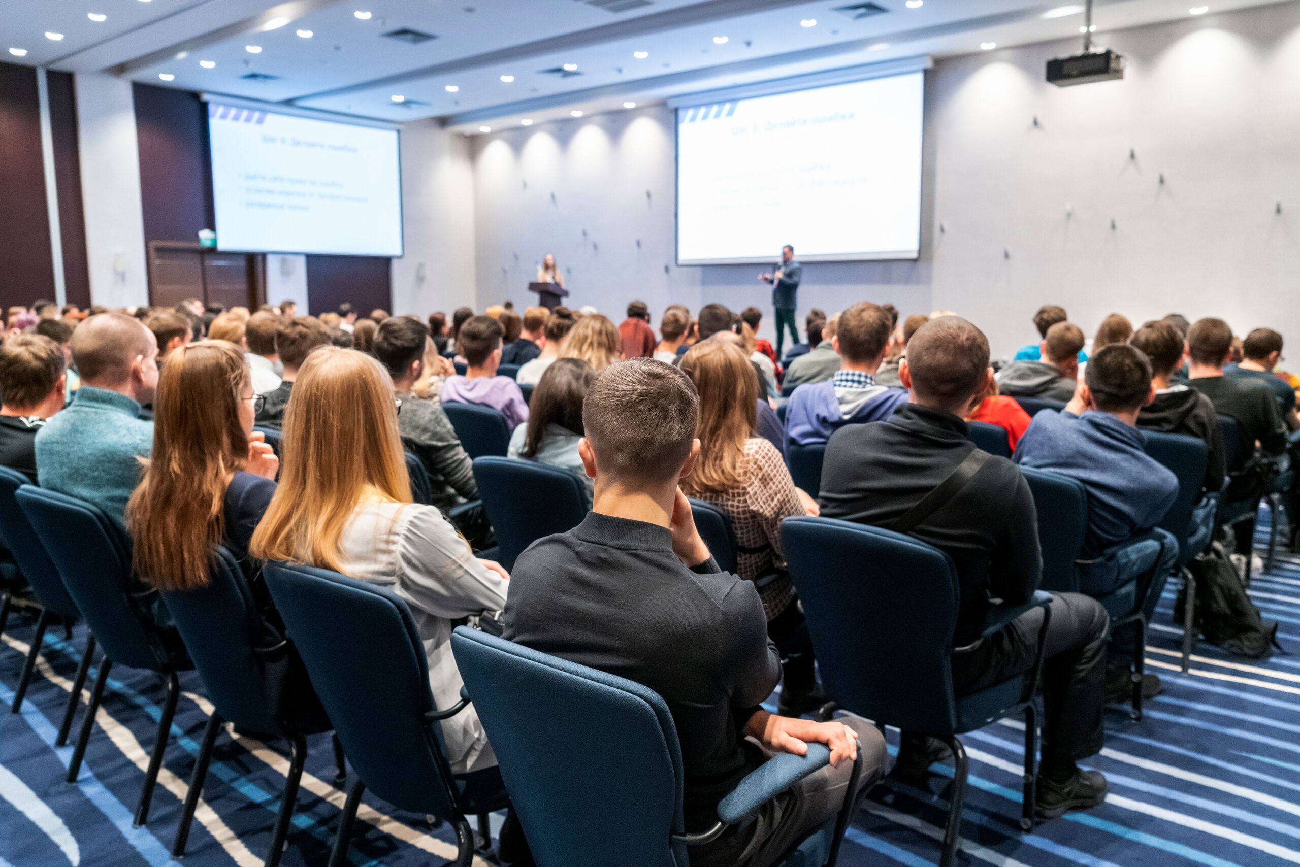 Image of a conference that takes place in a large conference roo