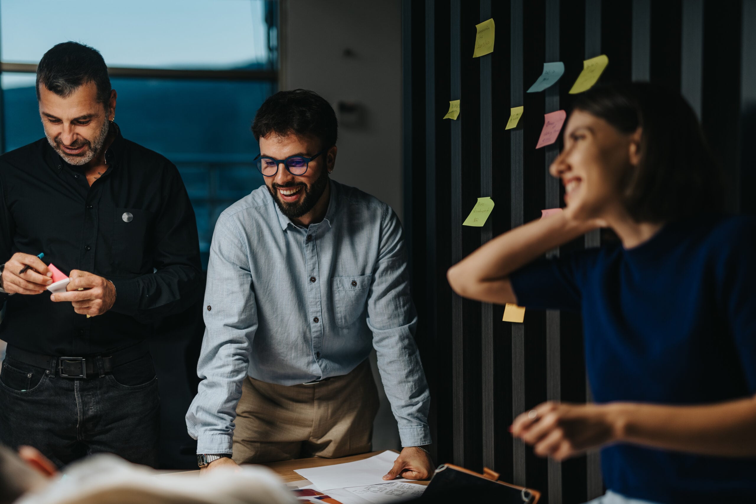 Different aged business team is engaged in a collaboration using colorful sticky notes, showcasing teamwork and innovation